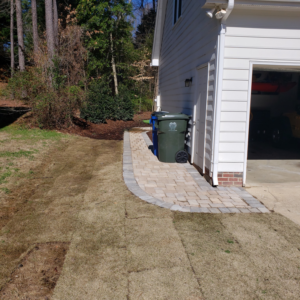 Newly installed paver walkway leading to a garage door, a handyman service by Raleigh Deck & Screen Porch Builder in Raleigh, NC