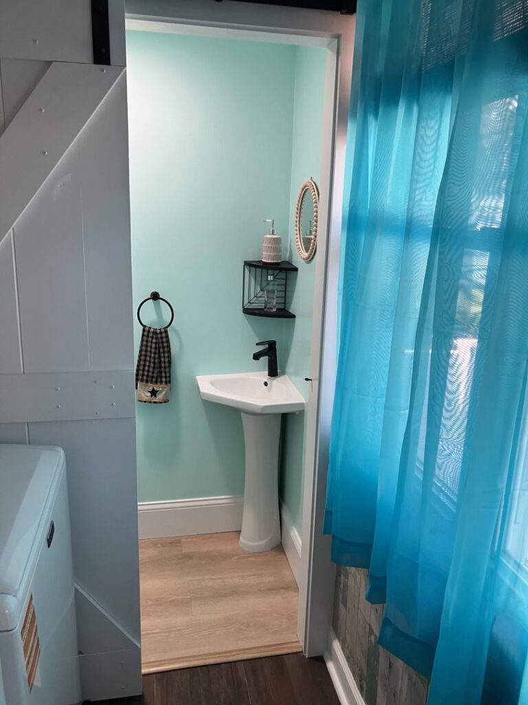 A newly installed pedestal sink and barn door in a bathroom by Dynamic Design & Remodeling in Westport, CT