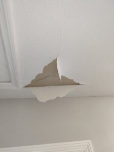 A damaged ceiling with peeling paint and cracks before repair by Ceiling Doctor by Julian, a handyman service in Augusta, GA.