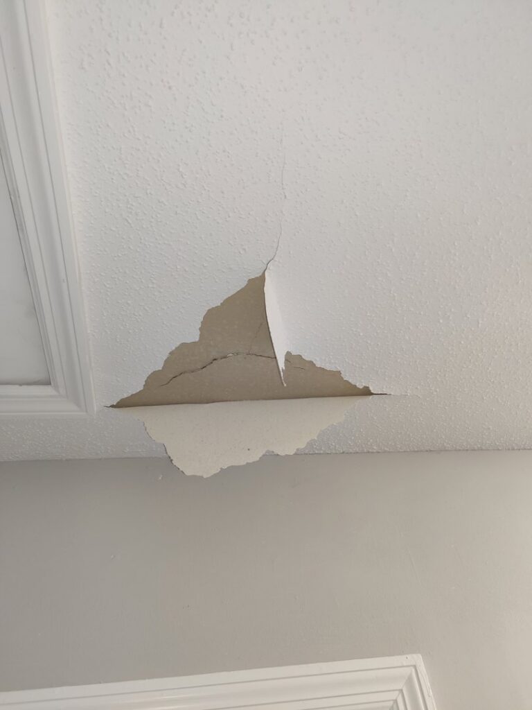 A damaged ceiling with peeling paint and cracks before repair by Ceiling Doctor by Julian, a handyman service in Augusta, GA.