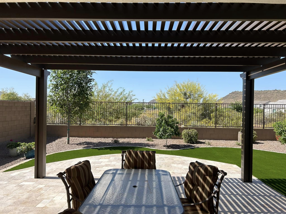 A completed brown pergola providing shade over a patio dining area by Az Sun Covers in Glendale, AZ.