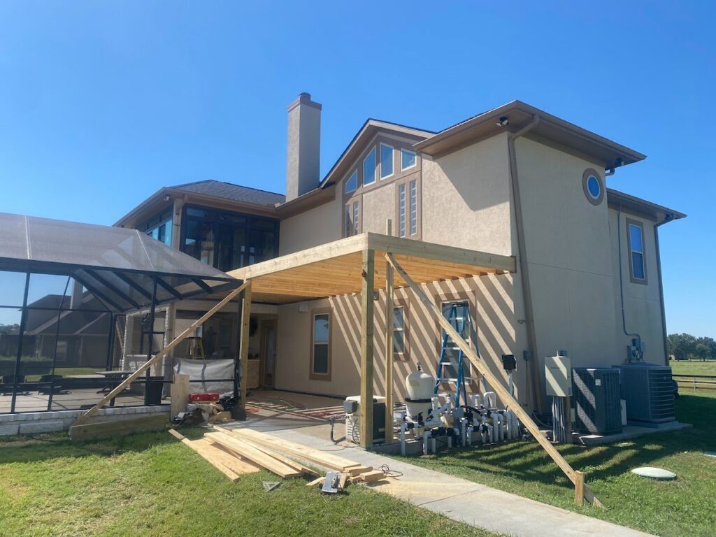 Wooden pergola or patio cover under construction next to a house and pool enclosure by SRP construction in Houston, TX