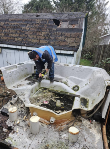 A worker breaking down an old hot tub for removal by Glenn's Junk & Landscape Hauling in Renton, WA.