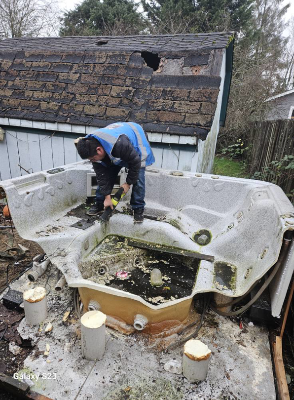 A worker breaking down an old hot tub for removal by Glenn's Junk & Landscape Hauling in Renton, WA.