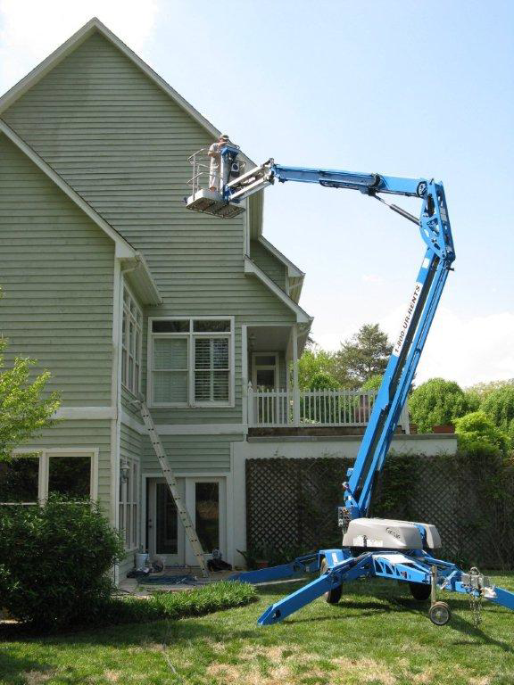 A person in a boom lift performing exterior siding work on a house for Steven Construction in Auburn, NY.