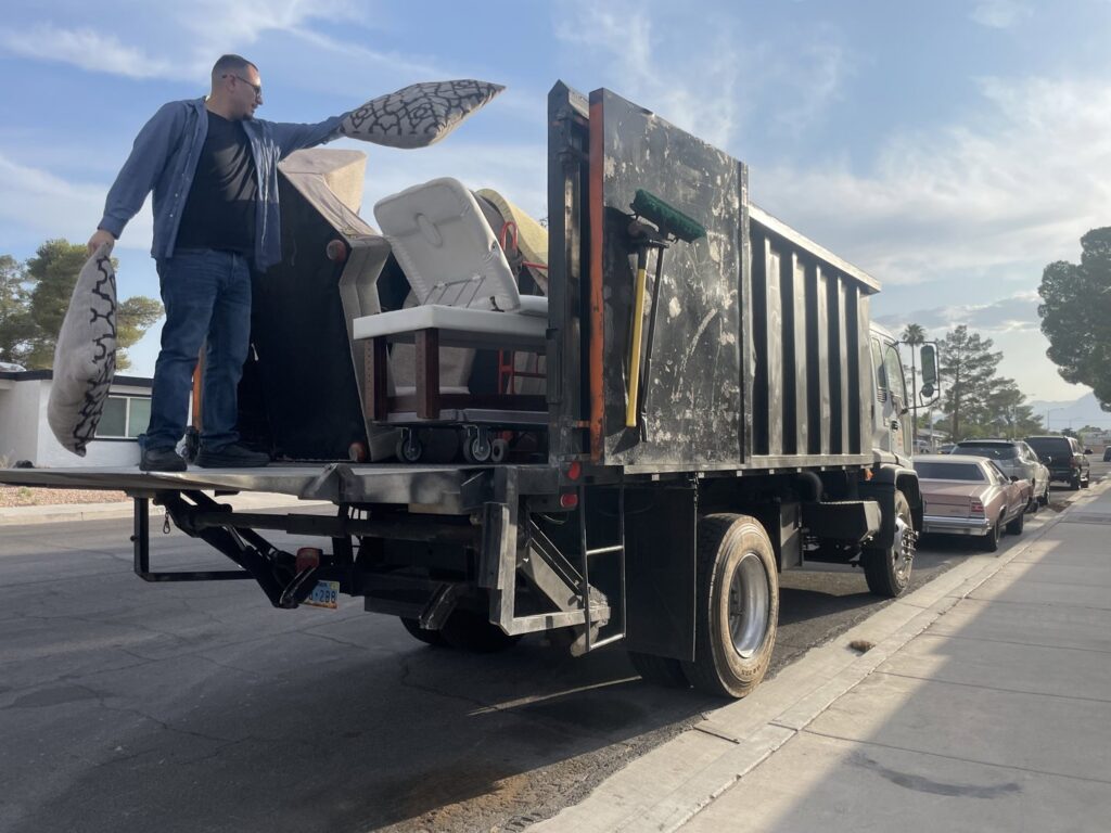 A Tidy Toss Las Vegas, NV team member loading furniture and pillows onto a junk removal truck.