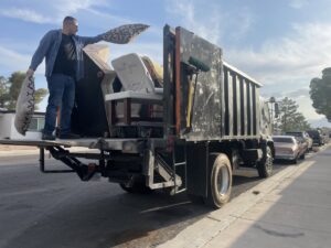 A Tidy Toss Las Vegas, NV team member loading furniture and pillows onto a junk removal truck.