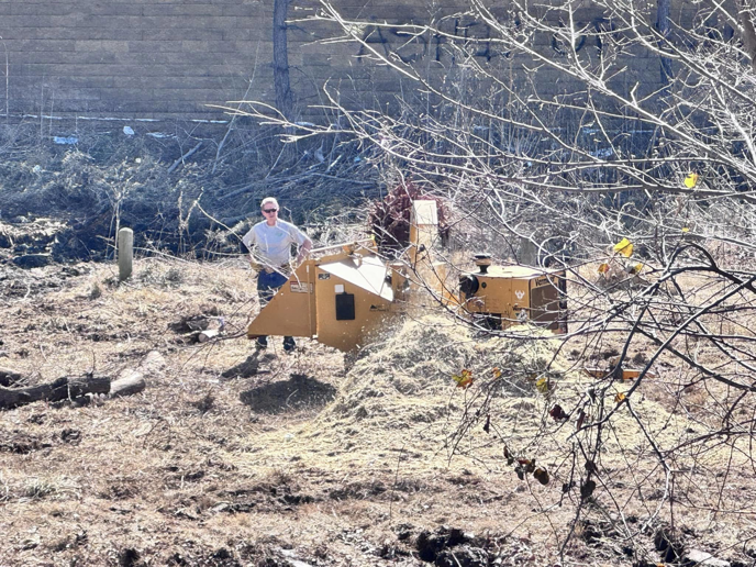 A person operating a wood chipper for land clearing and site preparation by HCR, Inc. in Boerne, TX.