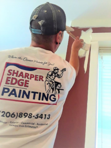 A person painting a wall and trim, showcasing a painting service by Sharper Edge Painting in Everett, WA.