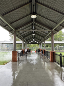 A person pressure washing a concrete walkway under a covered structure, performed by S & S Pressure Washing and Painting Co. in Burlington, NC.