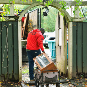 A JDog Junk Removal & Hauling Savannah/HHI team member removing a wooden cabinet from a property.