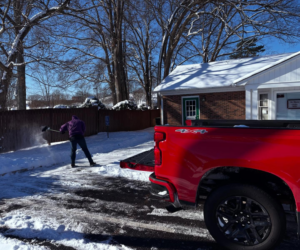 A person shoveling snow from a driveway, a handyman service offered by Canopy Crafters in Rock Hill, SC.