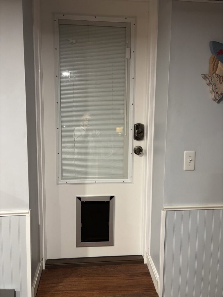 New pet door installed in a white entry door with built-in blinds by CWS Handyman LLC in Seekonk, MA