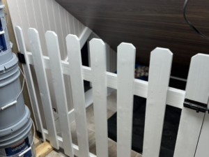A white pet safety gate installed at the bottom of stairs by JJ's Handyman Service in Las Vegas, NV