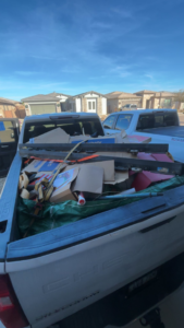 A pickup truck bed filled with various items and boxes for junk removal by Bin There Junk That in Phoenix, AZ.
