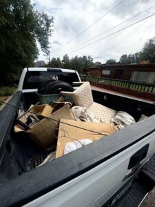 A richartehelps pickup truck bed loaded with tires, boxes, and miscellaneous junk for removal in Scottsdale, AZ.