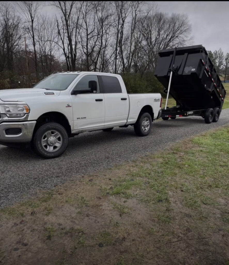 A white pickup truck with an attached black dump trailer, used for junk removal by The Removal Squad LLC in Orlando, FL.
