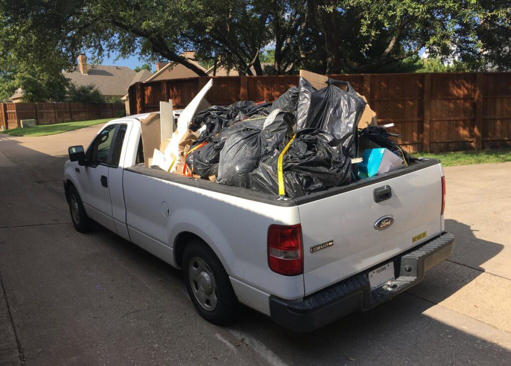 A pickup truck loaded with trash bags and various debris, ready for junk removal by MGM Household Services in Las Vegas, NV.