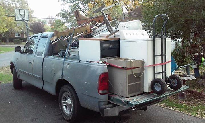 A pickup truck loaded with old appliances, furniture, and scrap metal, ready for hauling by MGM Junk Removal in Las Vegas, NV