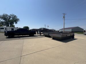 A black pickup truck hauling two roll-off dumpsters for ClearHouse Hauling in Huron, SD.