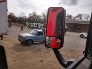 A blue pickup truck seen in a side mirror at the salvage yard of Queen City Metal Recycling & Salvage in Charlotte, NC.