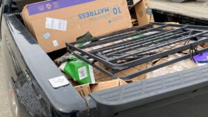 A pickup truck bed loaded with a mattress box, bed frame, and other household junk for removal by O'Brien Property Services in Clay, NY.