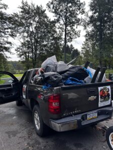 A Just Junk It pickup truck in Lancaster, PA, loaded with trash bags and various items for general junk removal.