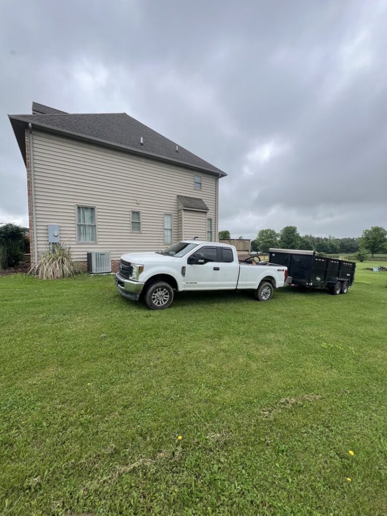A white pickup truck towing a utility trailer, used for junk removal by Dumpin' Junk in Martinsburg, WV.
