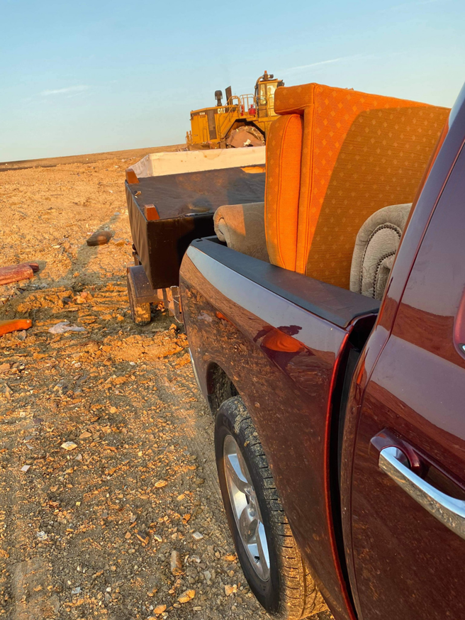 A pickup truck with a trailer loaded with furniture and other items for removal by Junk something ATX in Austin, TX