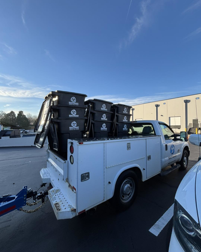 A pickup truck transporting multiple trash bins for Southeast Aquatics Trash in Raleigh, NC.