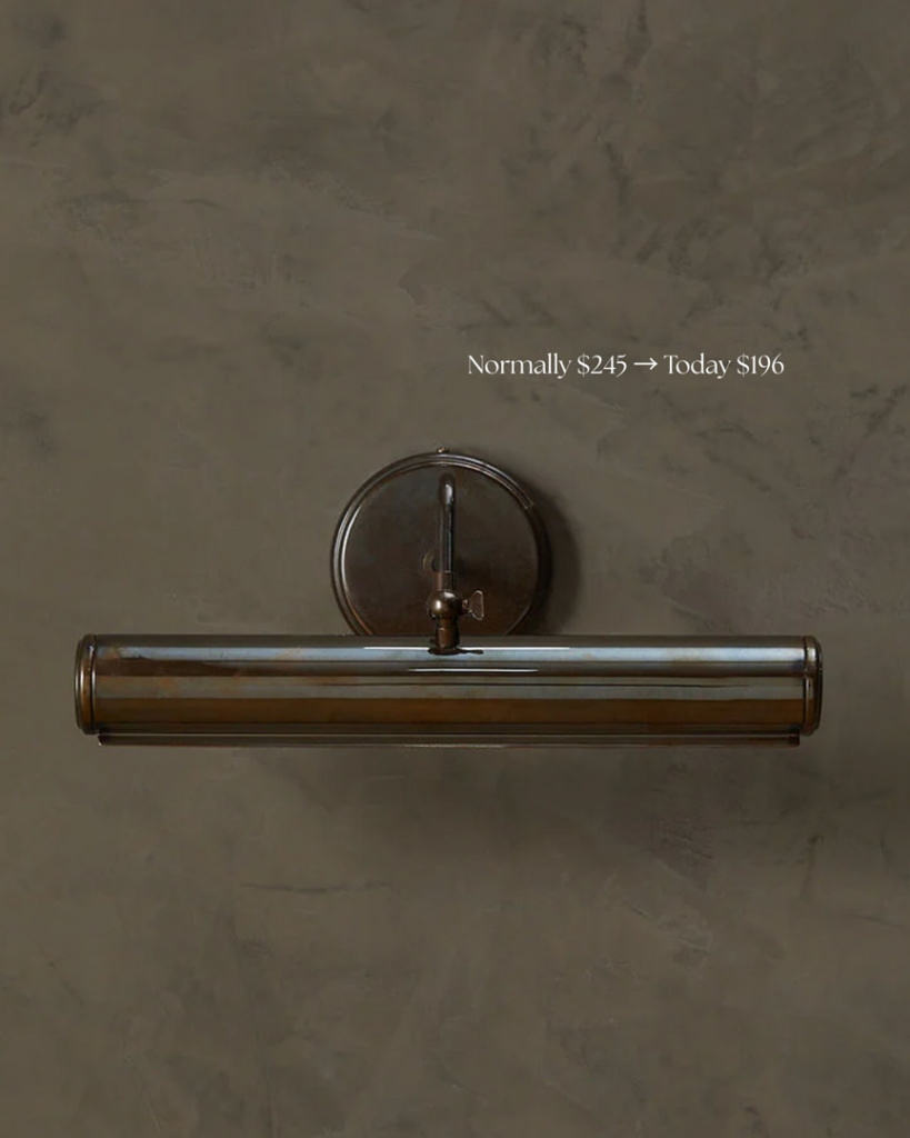 A modern bronze picture light mounted on a dark wall, showing specialized lighting installation by Wiersma Homes in Knoxville, TN.