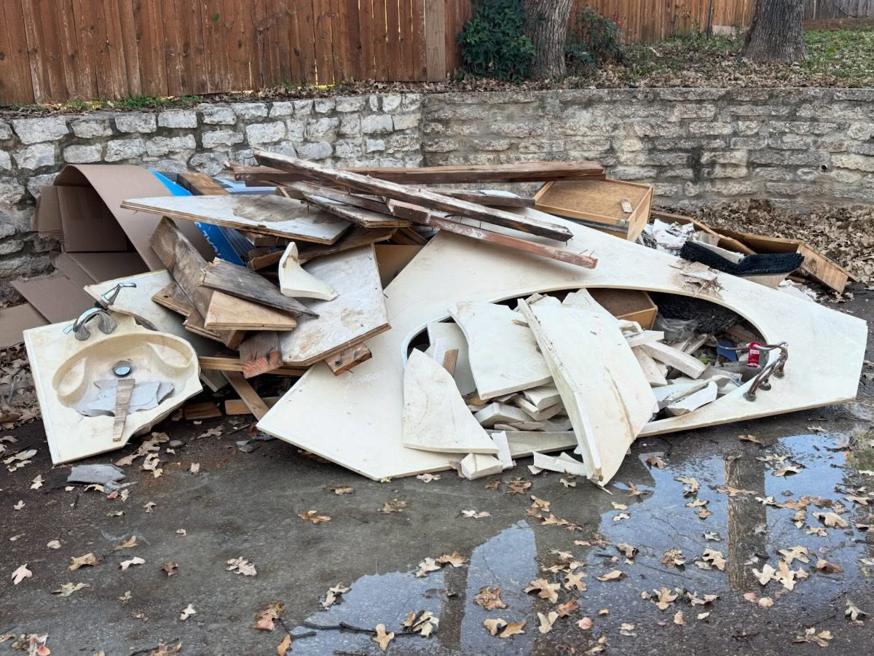 A large pile of construction debris, including broken sinks and wood, ready for junk removal by Grawe Junk & Demo in Arlington, TX.