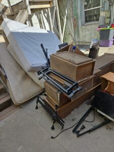 A large pile of mattresses, wooden furniture, and metal frames stacked outdoors for removal by Rubble Removers LLC in Riverton, WY.