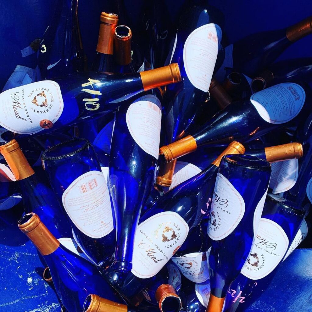 A close-up of blue glass bottles collected for recycling by Fisher Recycling in Charleston, SC.