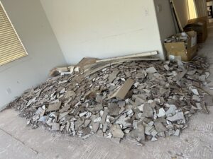 A large pile of broken tiles and construction debris on the floor, ready for removal by Tidy Toss Las Vegas, NV