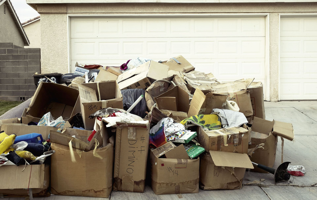 A large pile of cardboard boxes and household junk on a driveway, ready for removal by 1-888-PIK-IT-UP in Cary, NC.