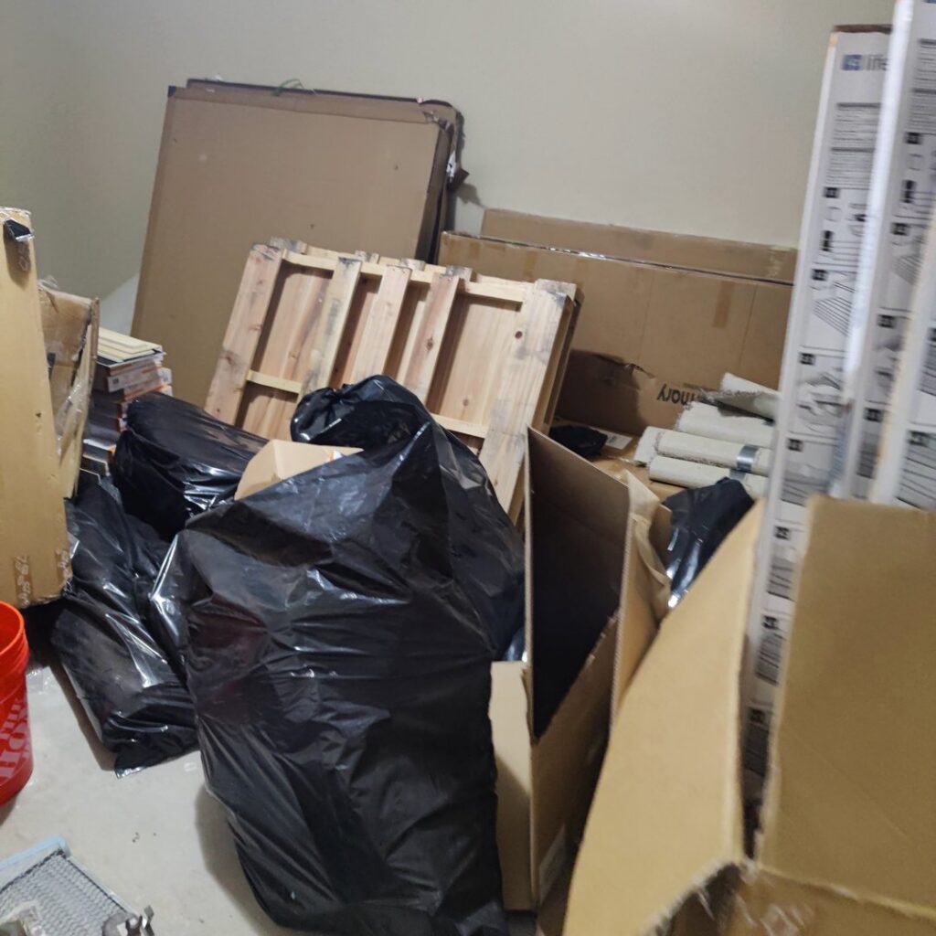 A pile of cardboard boxes and black trash bags ready for junk removal by Wilsa Junk Removal in Fort Lauderdale, FL.