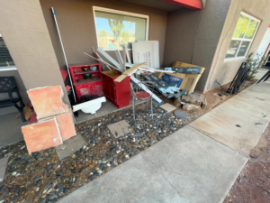 A large pile of construction debris and old items awaiting removal outside a building by Junk in the Truck LLC in Albuquerque, NM.
