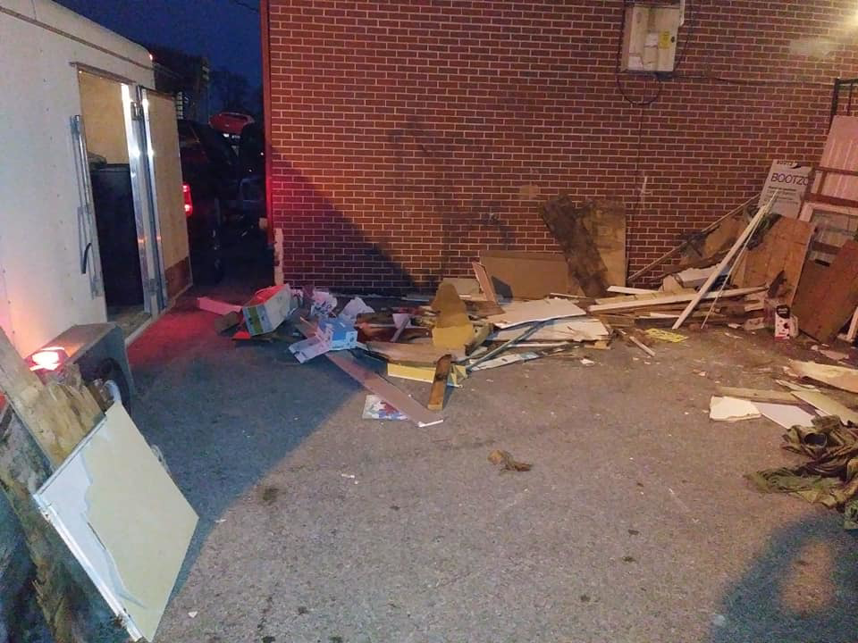 Construction debris and junk piled next to a trailer for C&C Dumpster Services in Omaha, NE.