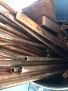A close-up view of a pile of copper pipes and tubing, collected for recycling by RZR Recycling in Phoenix, AZ.