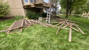 A pile of wooden deck debris on a residential lawn, awaiting junk removal by Haul-Away in Overland Park, KS.
