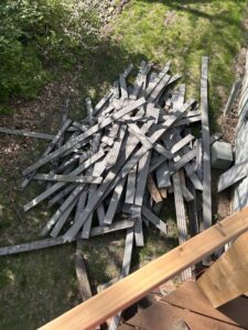 A pile of broken wooden planks from deck demolition, ready for removal by Junk Brothers in Louisa, KY.