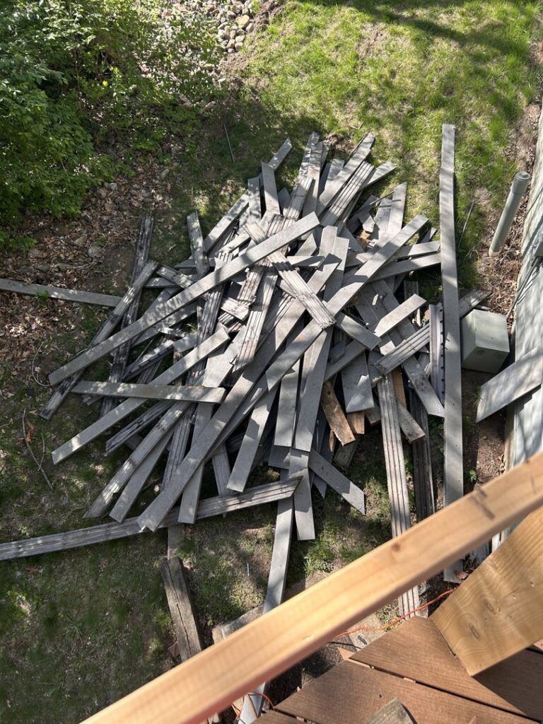 A pile of broken wooden planks from deck demolition, ready for removal by Junk Brothers in Louisa, KY.