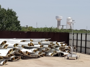 A large pile of decommissioned wind turbine blade sections collected for recycling by Global Fiberglass Solutions in Seattle, WA.