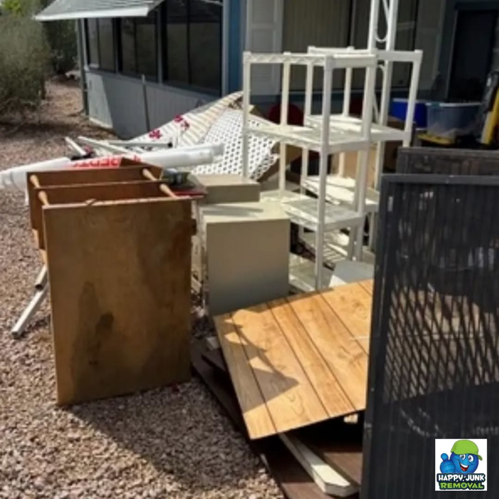 A large pile of household junk and debris awaiting removal by Happy Junk Removal outside a home in Mesa, AZ.