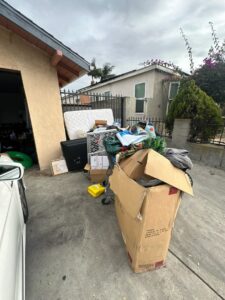 A large pile of household junk including a mattress, TV, and boxes, ready for removal by We-Haul Junk Removal in Long Beach, CA