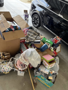 A large pile of household junk and boxes on a driveway, ready for removal by Bin There Junk That in Phoenix, AZ.