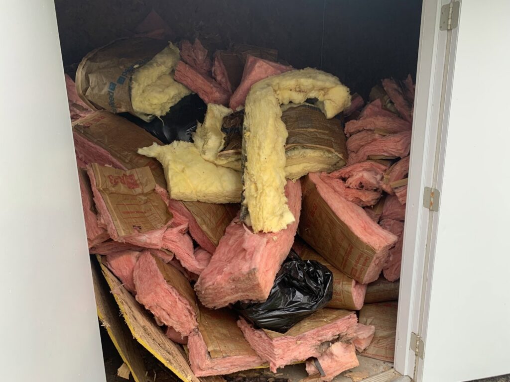 A large pile of insulation material inside a trailer, collected for removal by You Call We Haul Junk Removal in Milwaukee, WI.