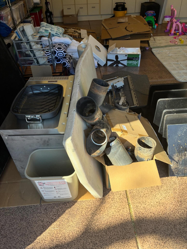 A pile of miscellaneous junk, including metal pipes, cardboard, and household items, ready for Tough Guy Junk Removal in Fountain Hills, AZ.