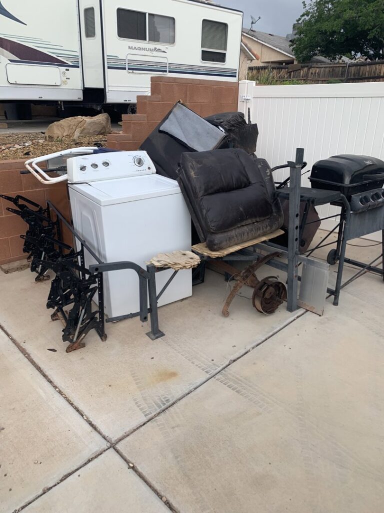 A pile of old appliances, a grill, and furniture ready for junk removal by YEE-HAul Trash Removal in St. George, UT.
